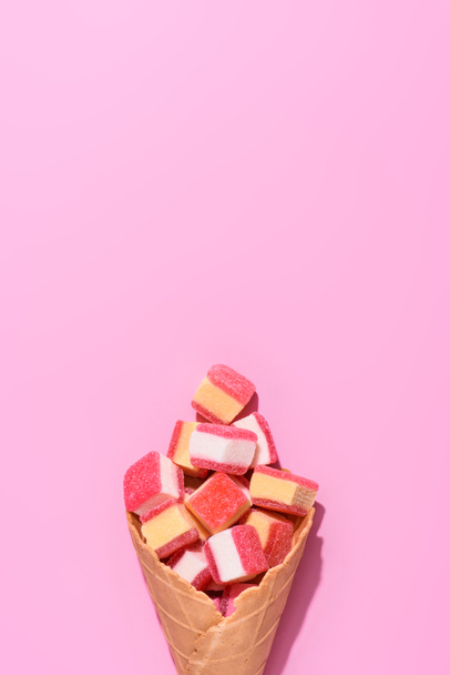 top view of sweet gummy candies in waffle cone on pink - Foto, afbeelding