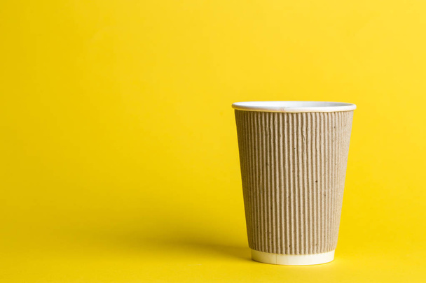 coffee to go in a disposable cup on a yellow background, place for text - 写真・画像