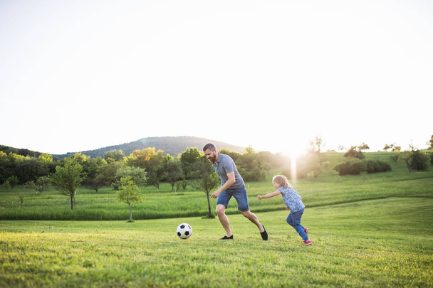 Father with a small daughter playing with a ball in spring nature. - Foto, imagen