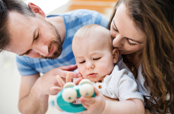 Young family and a baby boy with a toy at home. Close up. - Foto, Imagen