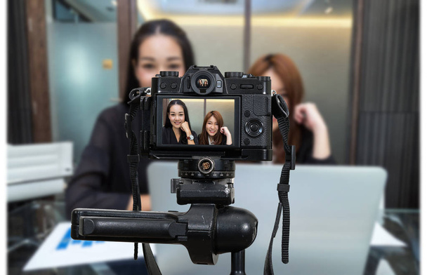 Ammattimainen digitaalinen peilitön kamera, jossa on mikrofonin tallennus videoblogi kahdesta aasialaisesta nuoresta liikenaisesta, kamera valokuvaajalle tai video- ja suoratoistokonsepti
 - Valokuva, kuva