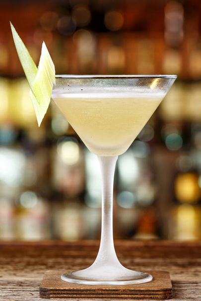 Ananascocktail alkoholin kanssa. Cocktail ginin, ananasmehun ja sellerin perusteella. Tuore cocktail baarissa
 - Valokuva, kuva
