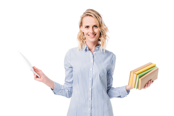 attractive woman holding tablet and books and looking at camera isolated on white - Foto, Imagen