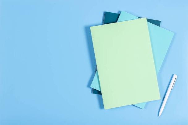 Cuadernos coloridos sobre fondo azul
 - Foto, Imagen