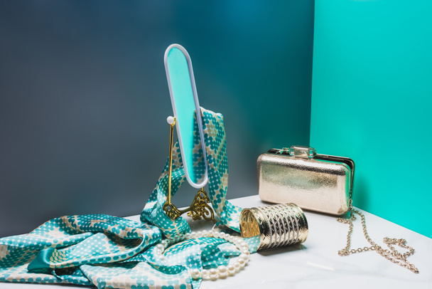 іграшкове дзеркало з шовковим шарфом і жіночими аксесуарами в мініатюрній синій кімнаті
 - Фото, зображення