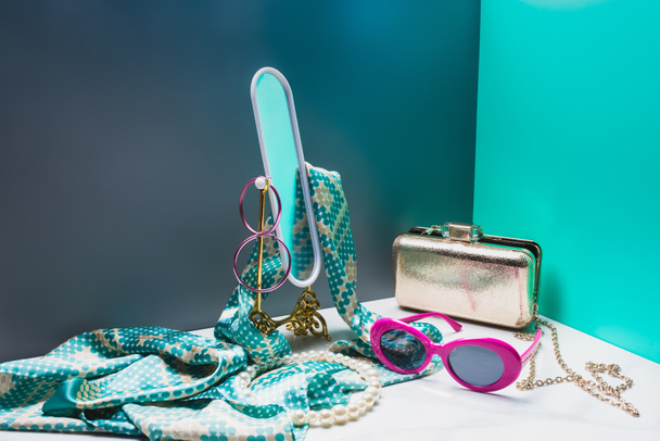 toy mirror with silk scarf and stylish female accessories in miniature blue room - 写真・画像