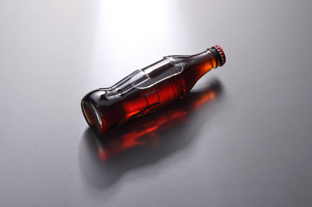 glass bottle of brown soda on gray background - Fotografie, Obrázek