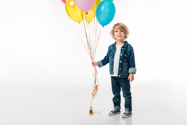 adorable boy holding bundle of colored balloons isolated on white - Foto, Imagem
