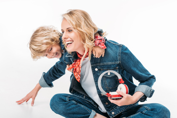 mother and son having fun together and holding headphones isolated on white - Valokuva, kuva