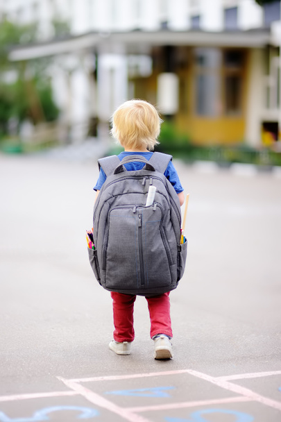 Cute little schoolboy outdoors on autumn day. Young student with his backpack. Education for small kids. Back to school concept. - Foto, Imagen