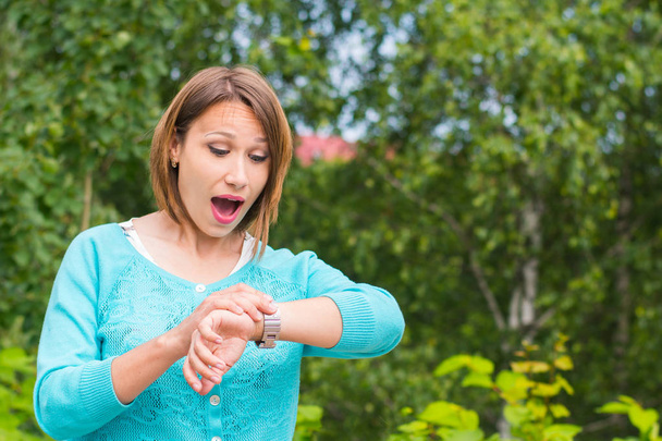 giovane donna guarda l'orologio sulla sua mano nel parco
 - Foto, immagini