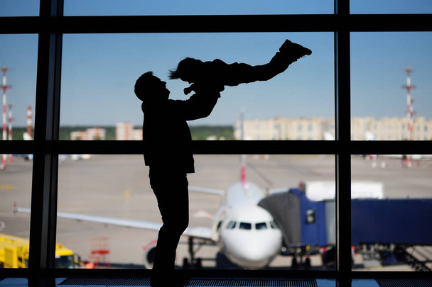 Man met kleine jongen plezier op de internationale luchthaven. Vader met zijn schattige kleine zoon wachten instappen. Familie reizen of immigratie concept - Foto, afbeelding