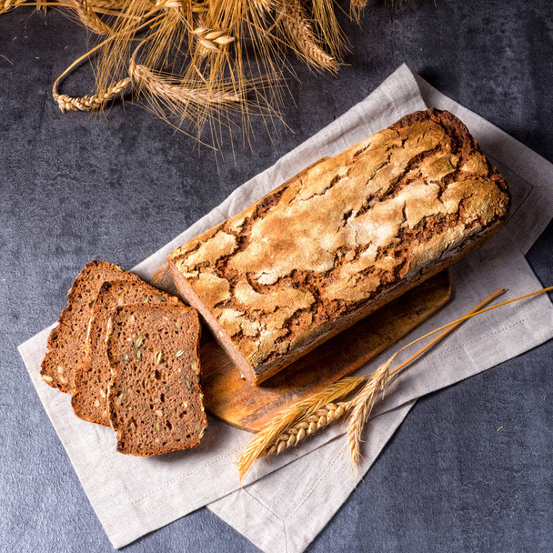 delicious homemade wholegrain bread with honey on chopping board - Fotó, kép