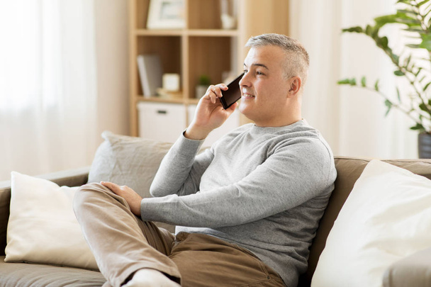 happy man calling on smartphone at home - Foto, imagen