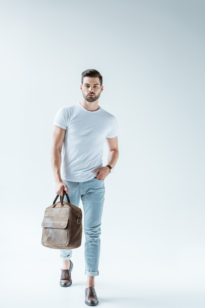 Fashionable confident man carrying briefcase on white background - Фото, изображение