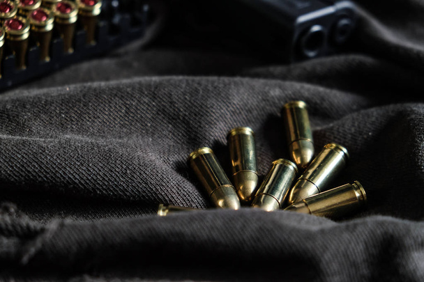 Pistolet semi-automatique 9mm avec balle FMJ sur tissu, concept de crime
 - Photo, image