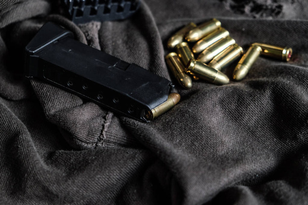 Full metal jacket 9mm ruger bullet on cloth texture arm object - Foto, imagen