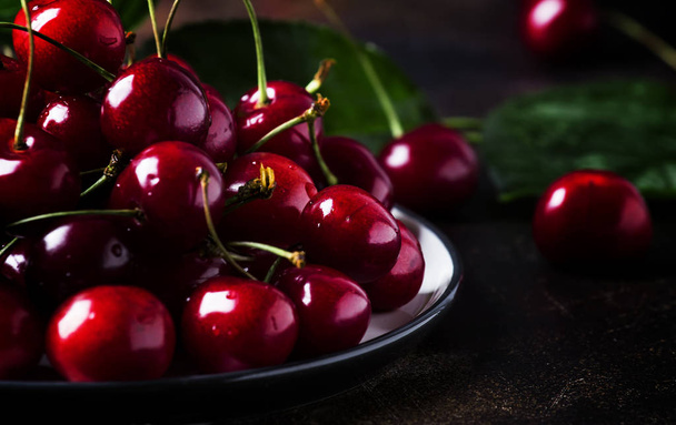 Red sweet cherries on brown table, selective focus - Фото, зображення