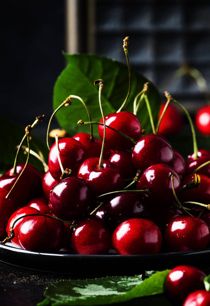 Red sweet cherries on brown table, selective focus - Fotó, kép