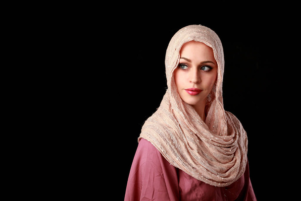 portrait of pretty girl wearing a pink headscarf. black studio background. - Photo, Image