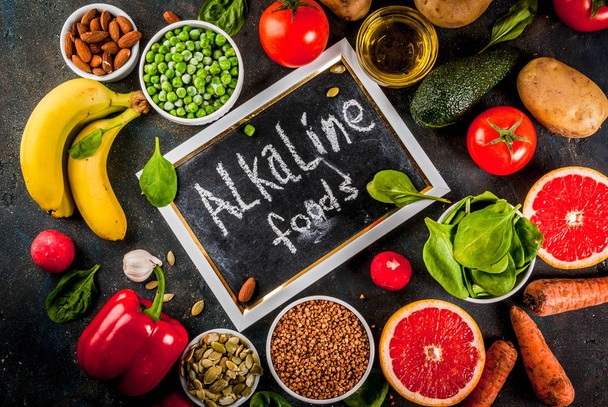 Gezonde voeding achtergrond, trendy Alkaline dieet producten - fruit, groenten, granen, noten. oliën, donker blauwe concrete achtergrond hierboven - Foto, afbeelding