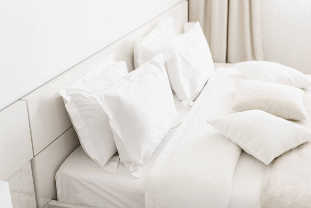Modern Çift Kişilik Yatak odası. Bir yatakta rahat yumuşak beyaz yastıklar. İç odalar bir daire veya otel. - Fotoğraf, Görsel