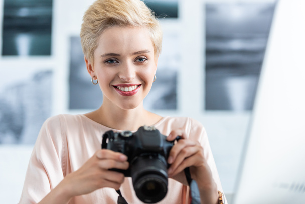 πορτρέτο του χαμογελαστό γυναίκα φωτογράφος κρατώντας τη φωτογραφική μηχανή φωτογραφιών  - Φωτογραφία, εικόνα