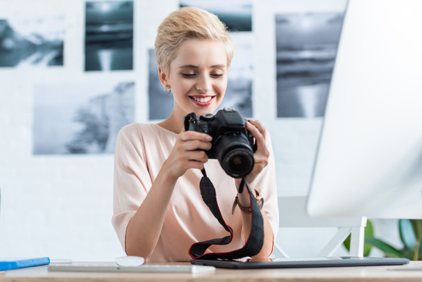 ev ofis bilgisayarı ile tablo kamera ekrana bakarak mutlu kadın fotoğrafçı - Fotoğraf, Görsel