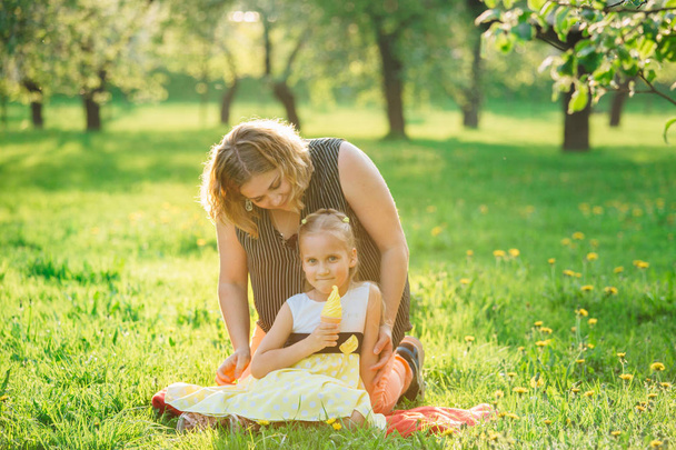 Mother and daughter having fun in the park. Happiness and harmony in family life.  Beauty nature scene with family outdoor lifestyle.  - 写真・画像