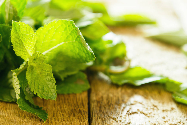 Bunch of fresh green mint on wooden table - Zdjęcie, obraz