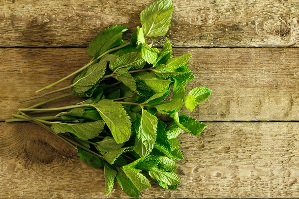 Bunch of fresh green mint on wooden table - Photo, image