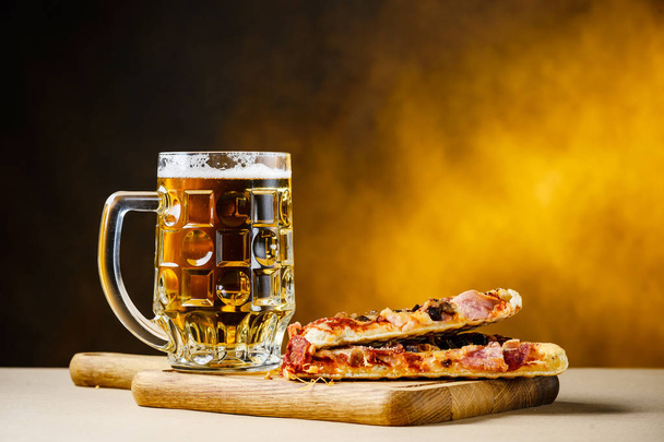 Finom házi pizza szelet szolgálják fel könnyű hideg sörrel - Fotó, kép