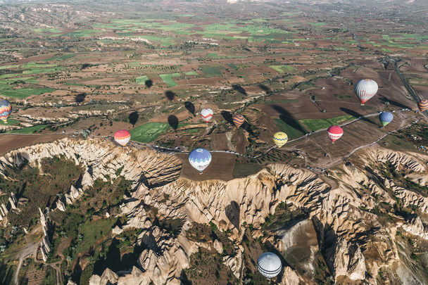 КАППАДОЦИЯ, ТУРЦИЯ - 09 МАЯ 2018 г.: вид с воздуха на различные красочные воздушные шары, летящие над каппадокией, индейку
 - Фото, изображение