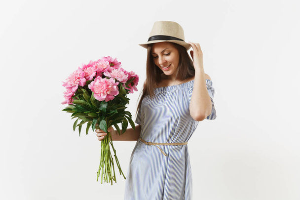 Young tender woman in blue dress, hat holding bouquet of beautiful pink peonies flowers isolated on white background. St. Valentine's Day, International Women's Day holiday concept. Advertising area - Foto, Imagen