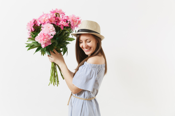白い背景の上に青いドレス、美しいピンク色の牡丹の花の花束を持って帽子の若い柔らかい女性が分離されました。聖バレンタインの日、国際女性の日の休日の概念。広告エリア - 写真・画像