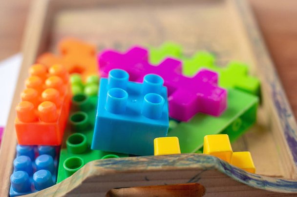 Toy colorful plastic blocks on wooden floor background - Photo, Image