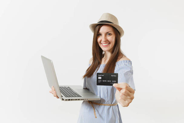 Young elegant woman working on modern laptop pc computer, holding credit card, money isolated on white background. Finance, freelance, business, online shopping concept. Mobile Office. Advertising - Foto, Bild