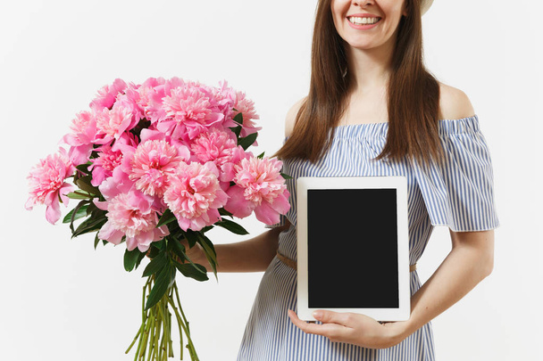 Nainen tilalla tabletti tietokone tyhjä näyttö kopioida tilaa, kimppu kauniita vaaleanpunaisia pioneja kukkia eristetty valkoisella taustalla. Business toimitus verkkokaupoissa käsite. Mainonta
 - Valokuva, kuva