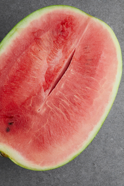 top view of fresh watermelon cut half on grey concrete tabletop - Photo, Image