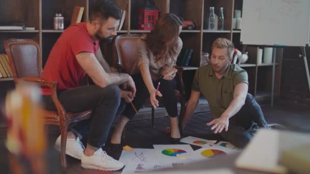 Creatieve business mensen discussie markt grafiek op verdieping in gezellige studio - Video