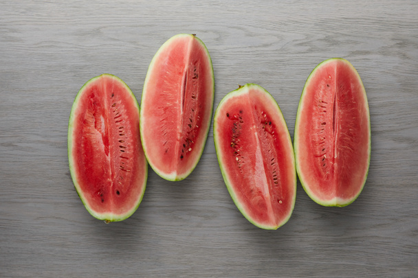 top view of arranged fresh watermelon slices on grey wooden surface - Fotoğraf, Görsel