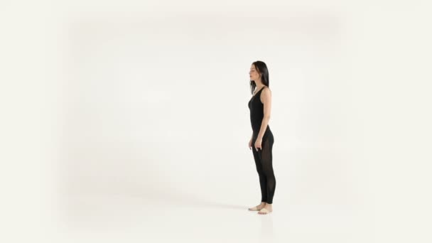 Young attractive woman doing acrobatics somersault. Elegant ballet dancer stretching on white background. - Metraje, vídeo