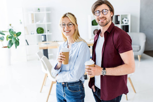 Kollegen von Startup-Projekt halten Einweg-Kaffeetassen im Büro - Foto, Bild