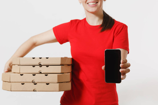 Nő a piros sapka, póló ad élelmiszer rendelés olasz pizza kartonpapírból flatbox ládákban elszigetelt fehér background. Női futár gazdaság mozgatható telefon-val üres fekete üres képernyő. Szállítás fogalma - Fotó, kép
