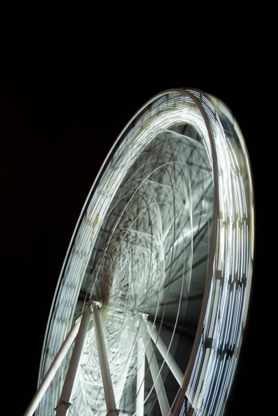 selective focus of blurred observation wheel at night on black background - Photo, Image