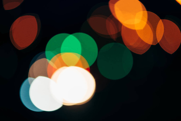 close up view of colorful bokeh lights on dark background - Foto, imagen