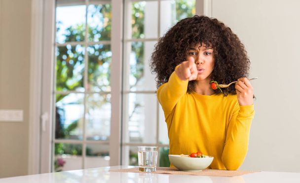 アフリカ系アメリカ人の女性がカメラと、手話、正面からポジティブで自信のジェスチャーと指差し呼称パスタ サラダを食べて - 写真・画像