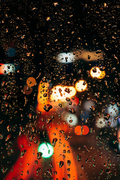 Vista de cerca de las gotas de lluvia en la ventana y las luces de la ciudad bokeh en el fondo
 - Foto, Imagen