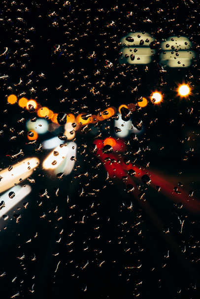Lähikuva näkymä sadepisarat ikkunassa ja bokeh kaupungin valot taustalla
 - Valokuva, kuva
