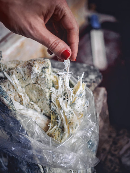 Schnittwunden an Frau beim Reißen von hausgemachtem Tschechil-Käse - Foto, Bild